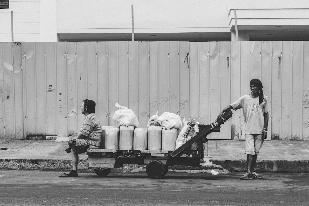 a black and white photo of two people on a street