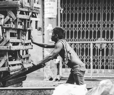 a black and white photo of a man pushing a cart