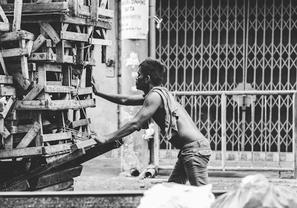 a black and white photo of a man pushing a cart