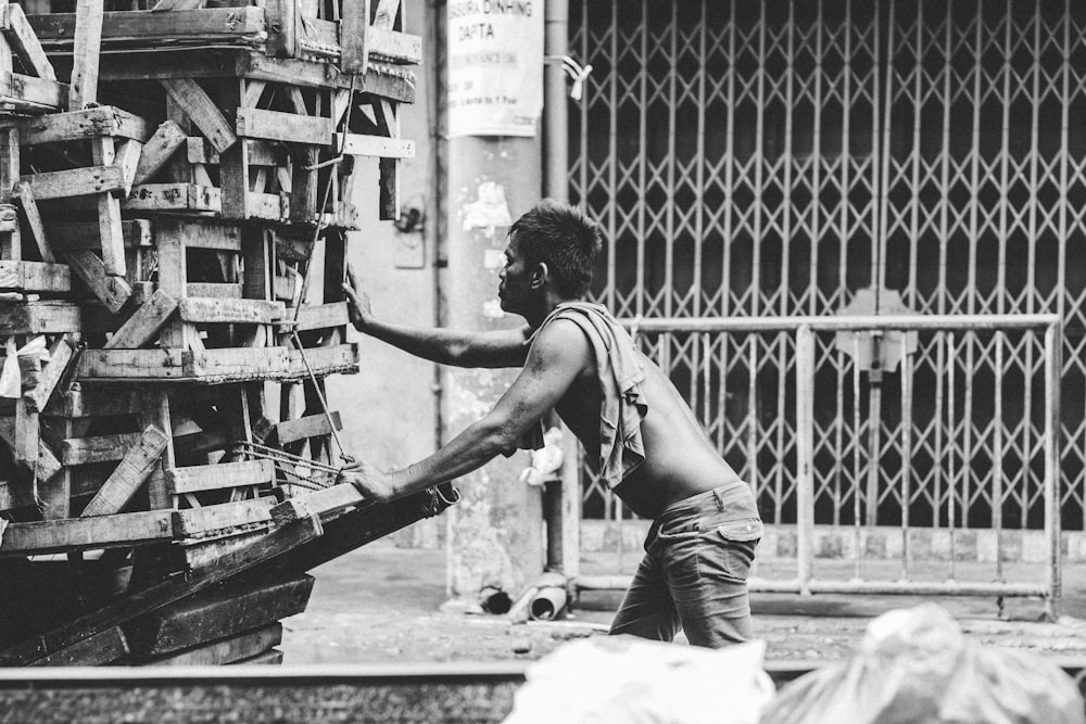 a black and white photo of a man pushing a cart