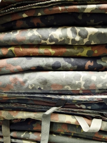 Folded military-grade tarp with visible reinforced edges and grommets, ready for transport.