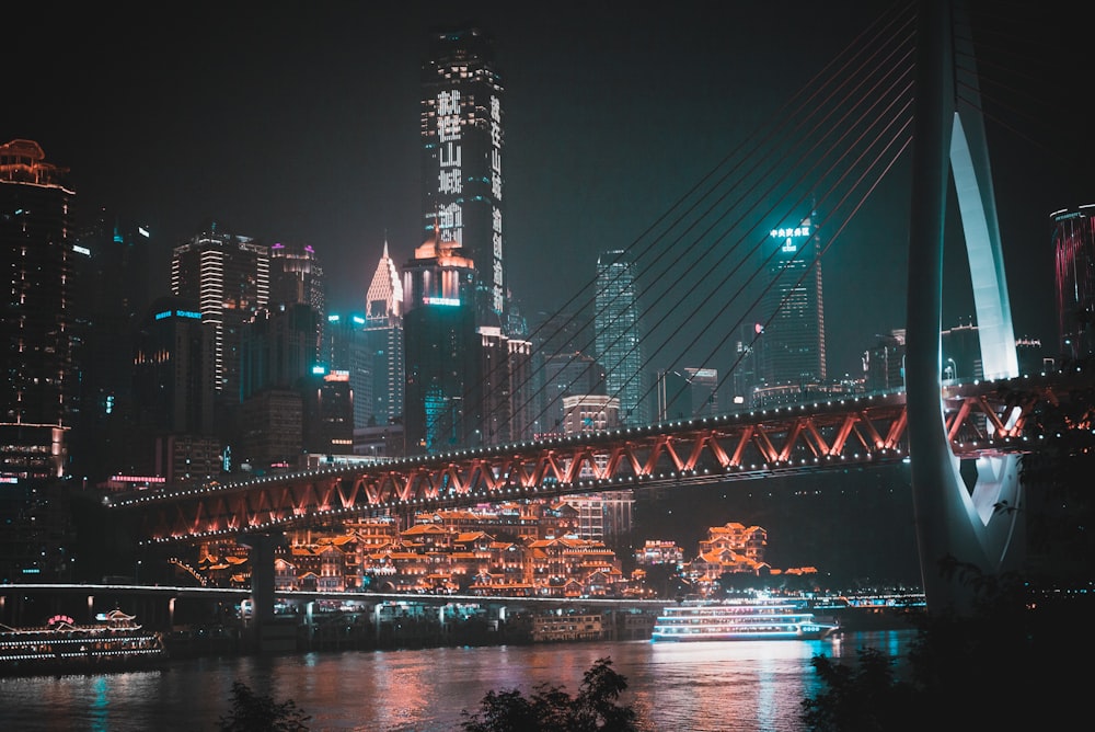 ship on body of water near bridge and buildings at night