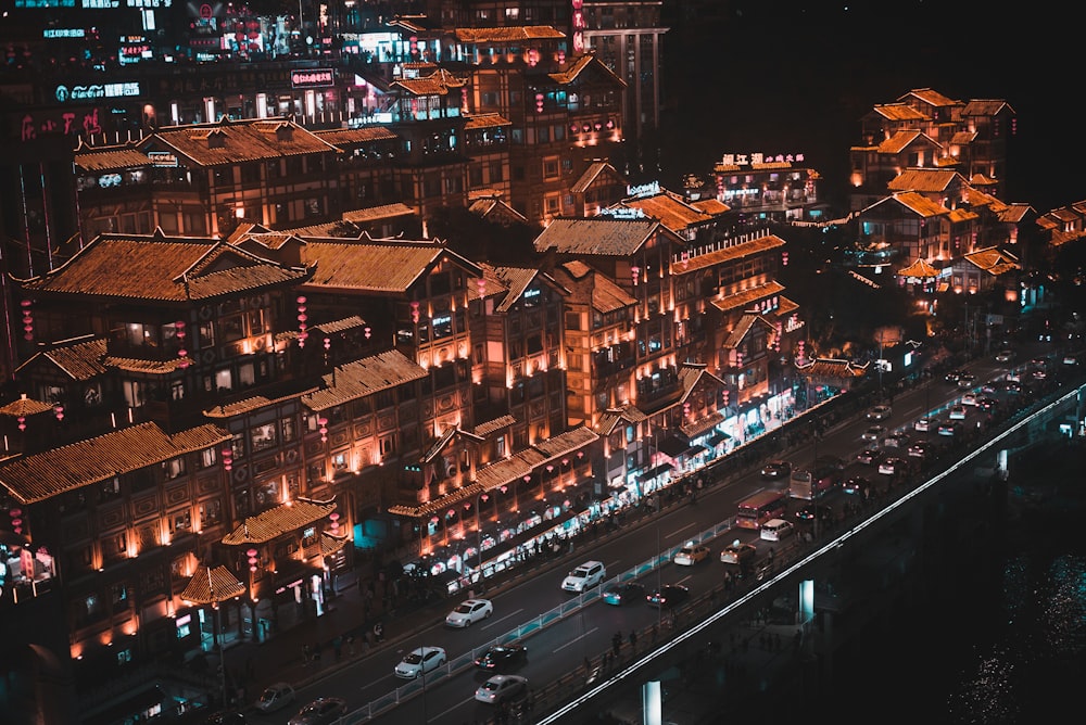 aerial photography of different vehicles on road viewing houses during night time