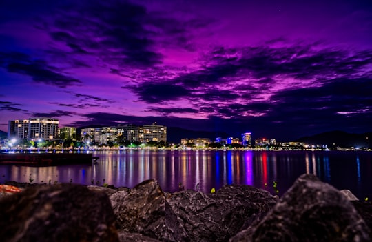 grey seashore rock with view of city skyline during night time in Esplanade Australia