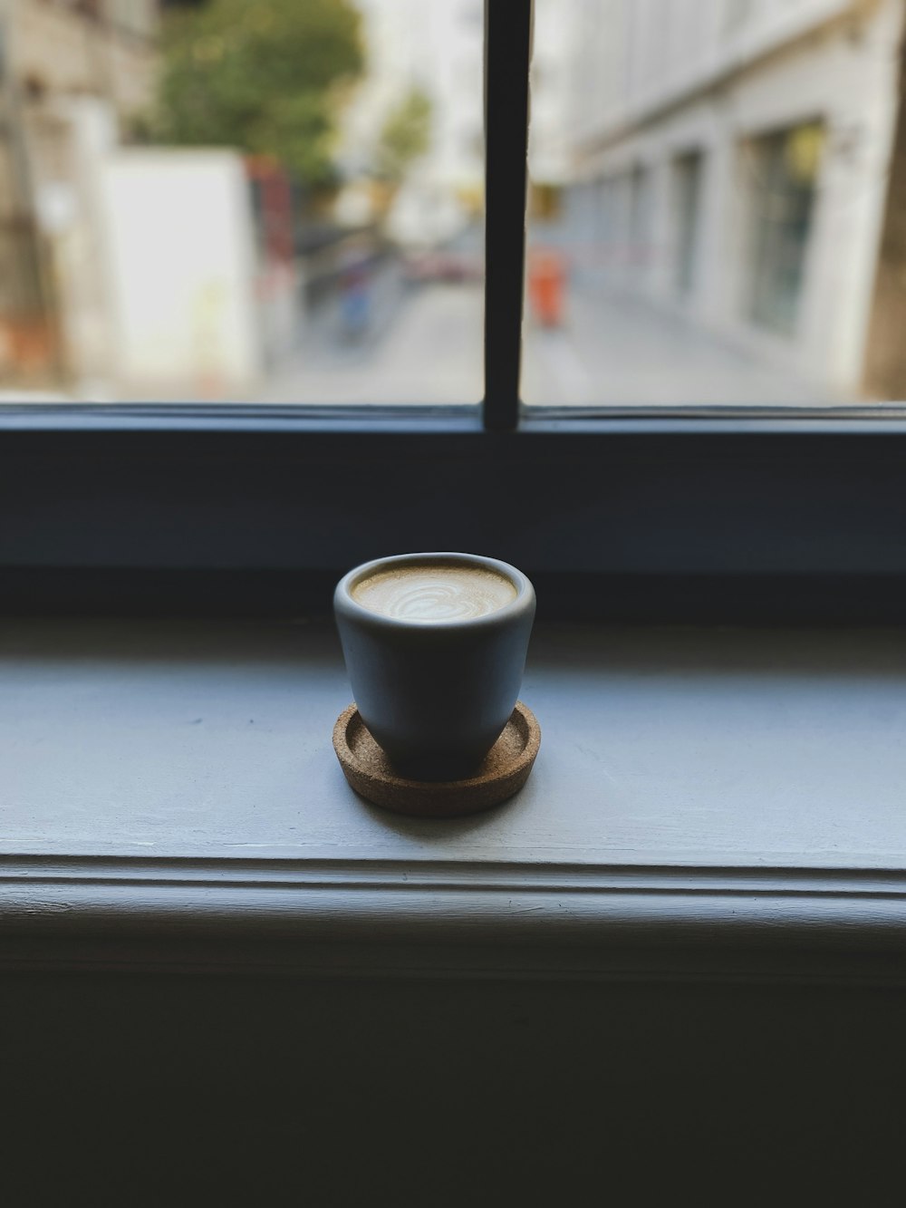 blue ceramic mug near the window