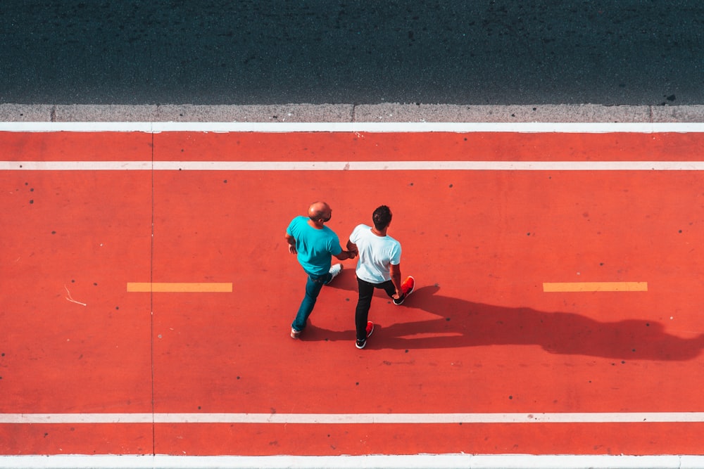 two men walking on orange road