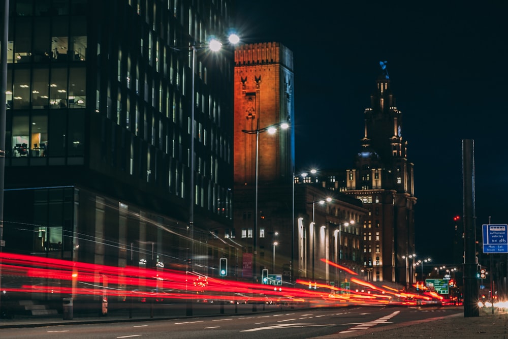 Fotografía de lapso de tiempo de la carretera y la ciudad con edificios de gran altura durante la noche