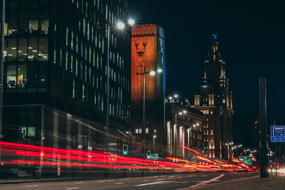 time-lapse photography of road and city with high-rise buildings during night time