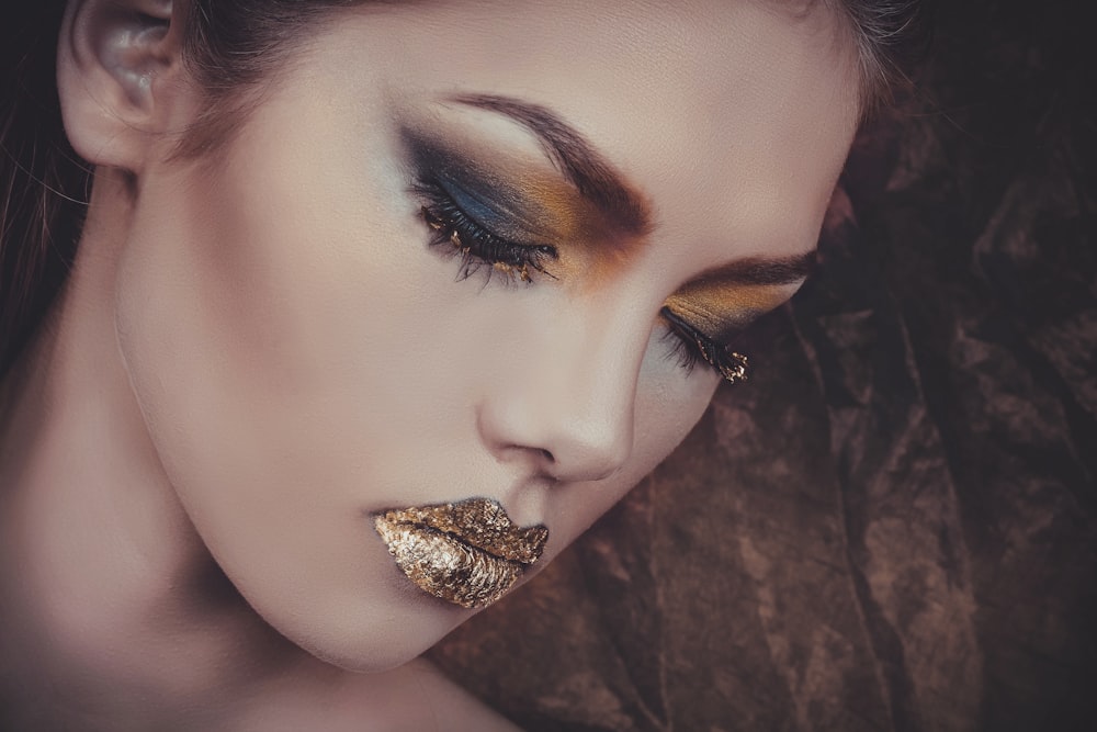 woman with gold lipstick and orange and gray eyeshadow