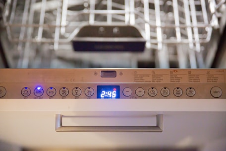 A close-up of a dishwasher being serviced with tools nearby.