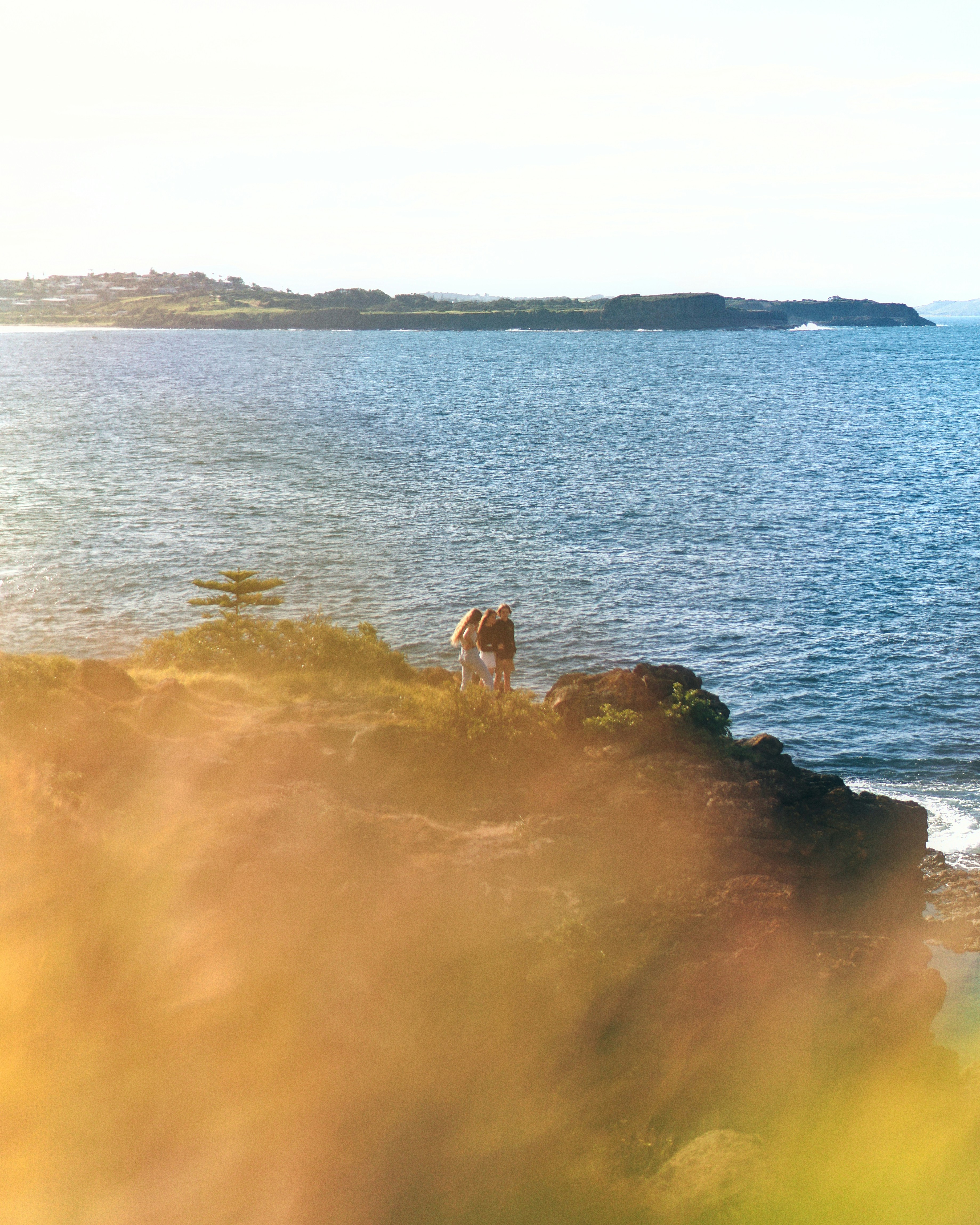 two people on mountain near body of water