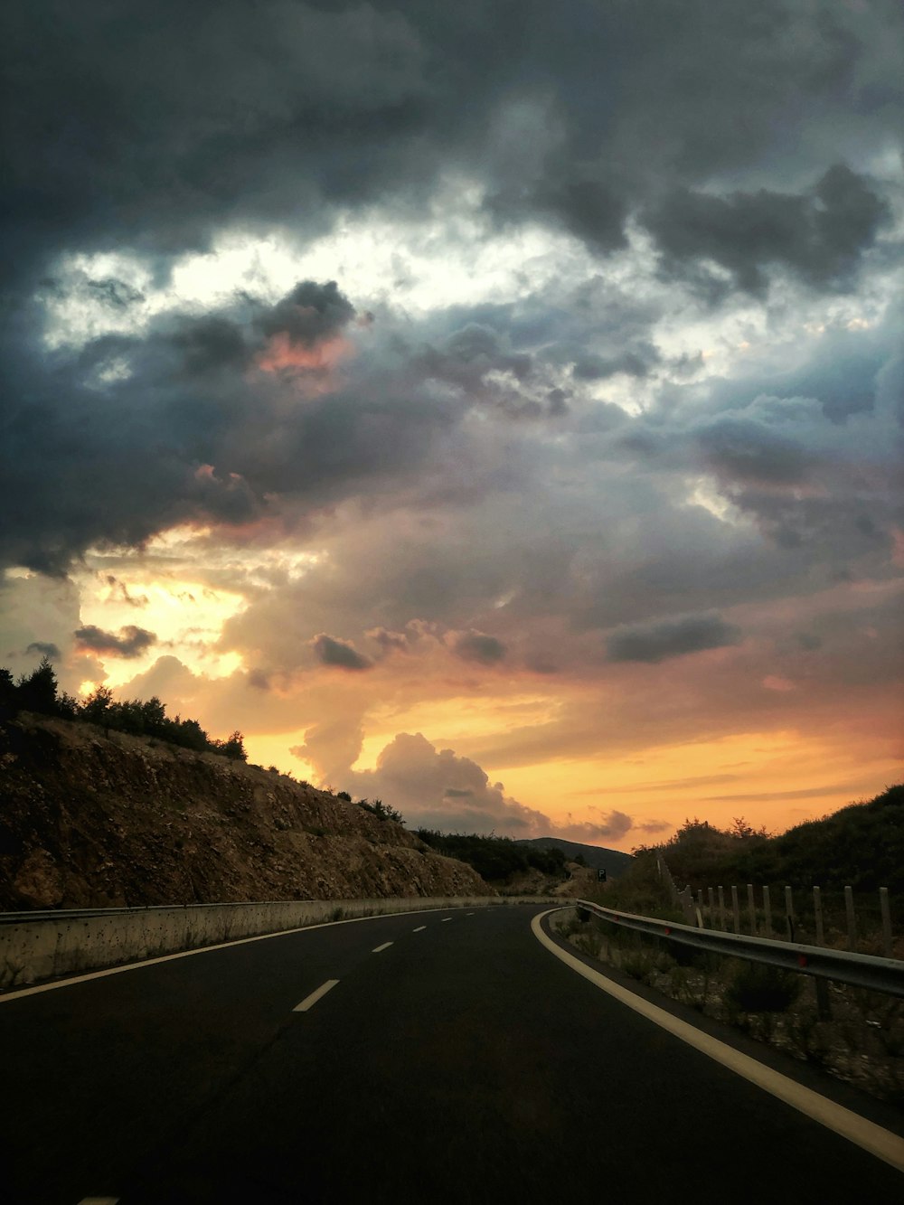 asphalt highway during cloudy day