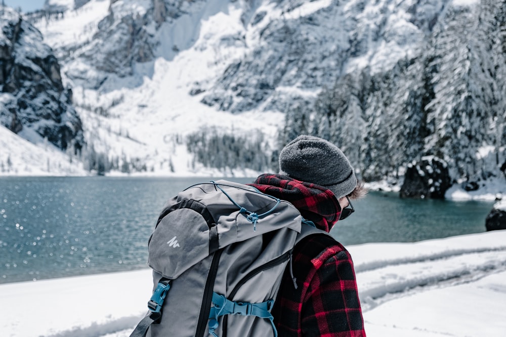 red and black checked hoodie walking near lake during winter