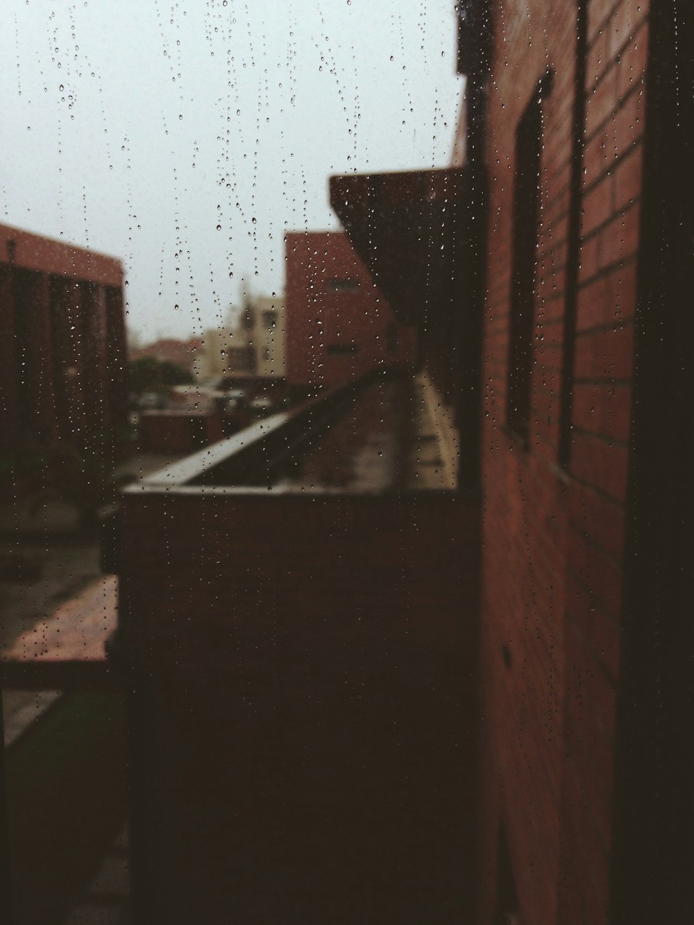 a view of a building through a rain soaked window