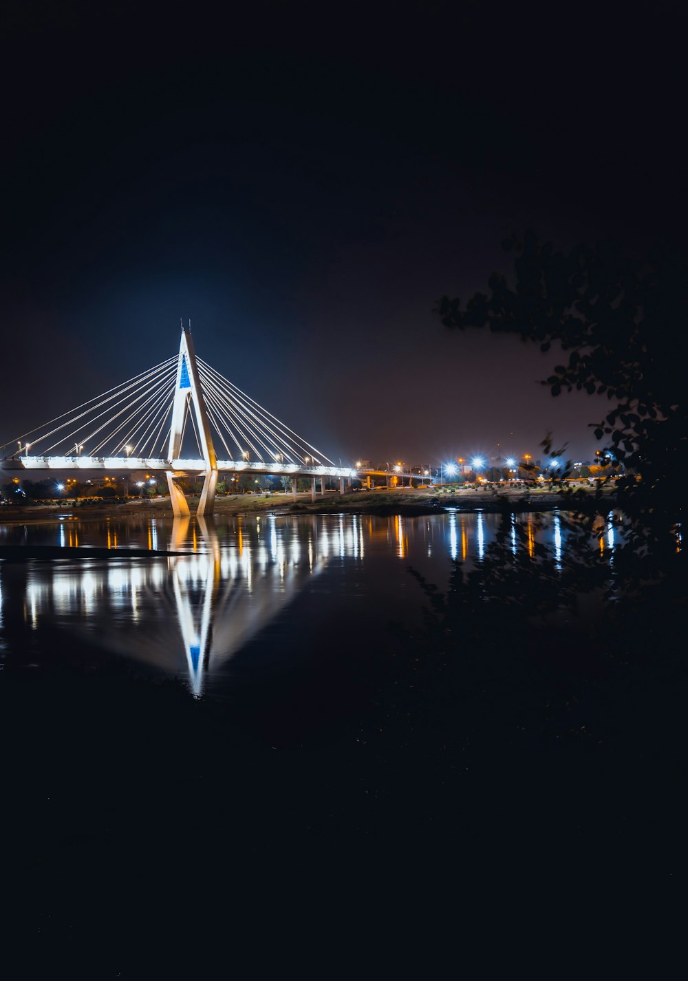 Specchio d'acqua sotto il ponte vicino alla città di notte