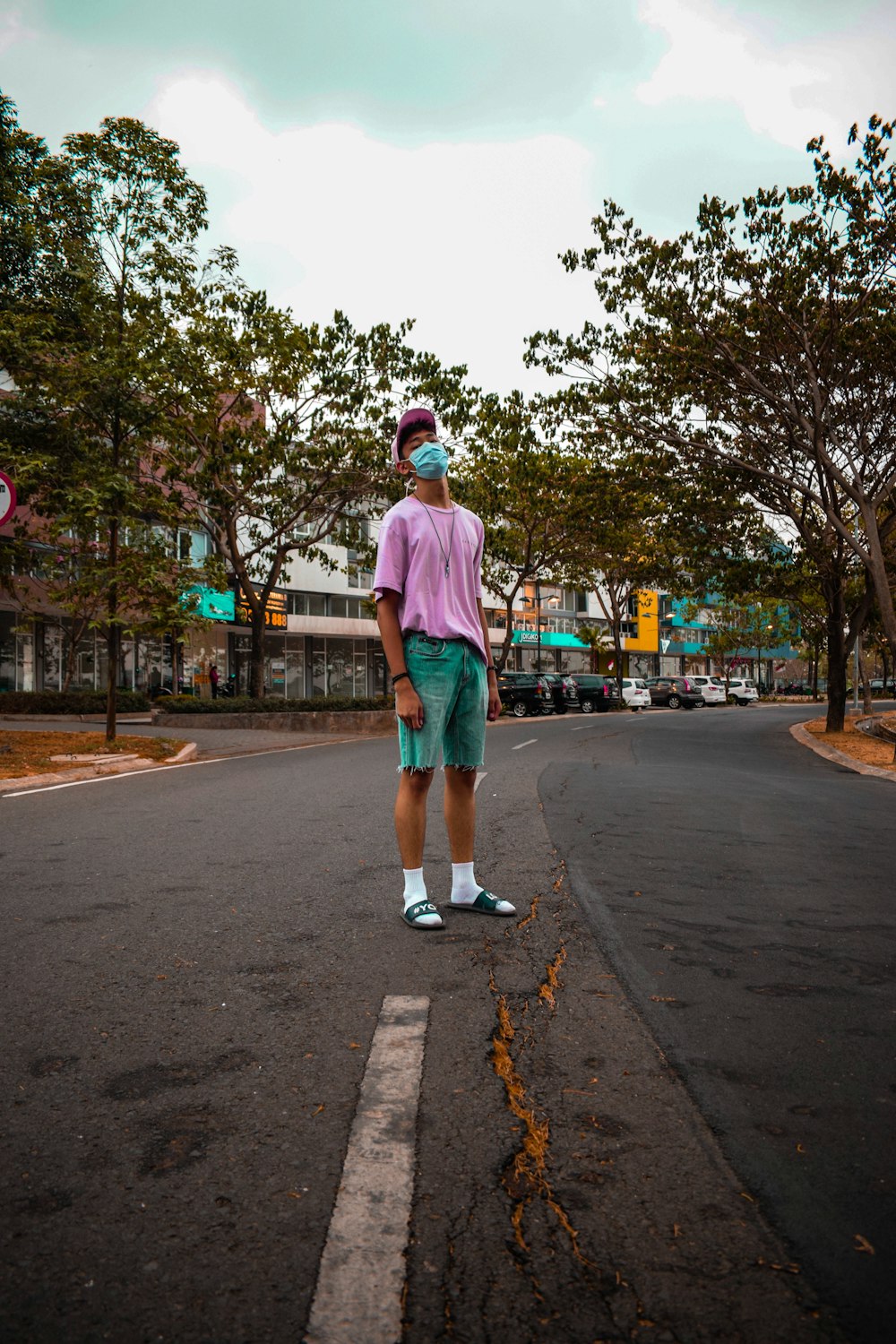 man standing on road near trees during daytime