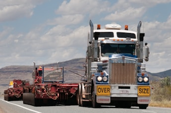 A large transport truck maneuvering an oversized load on a highway.