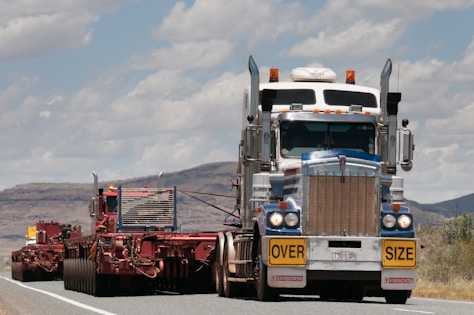 A heavy-duty truck transporting oversized cargo on a highway.