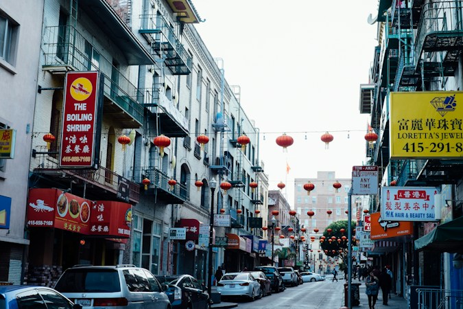 Cars parked along a commercial sidewalk during the day, similar to the shopping plaza parking that fills up along the Las Vegas Chinatown corridor