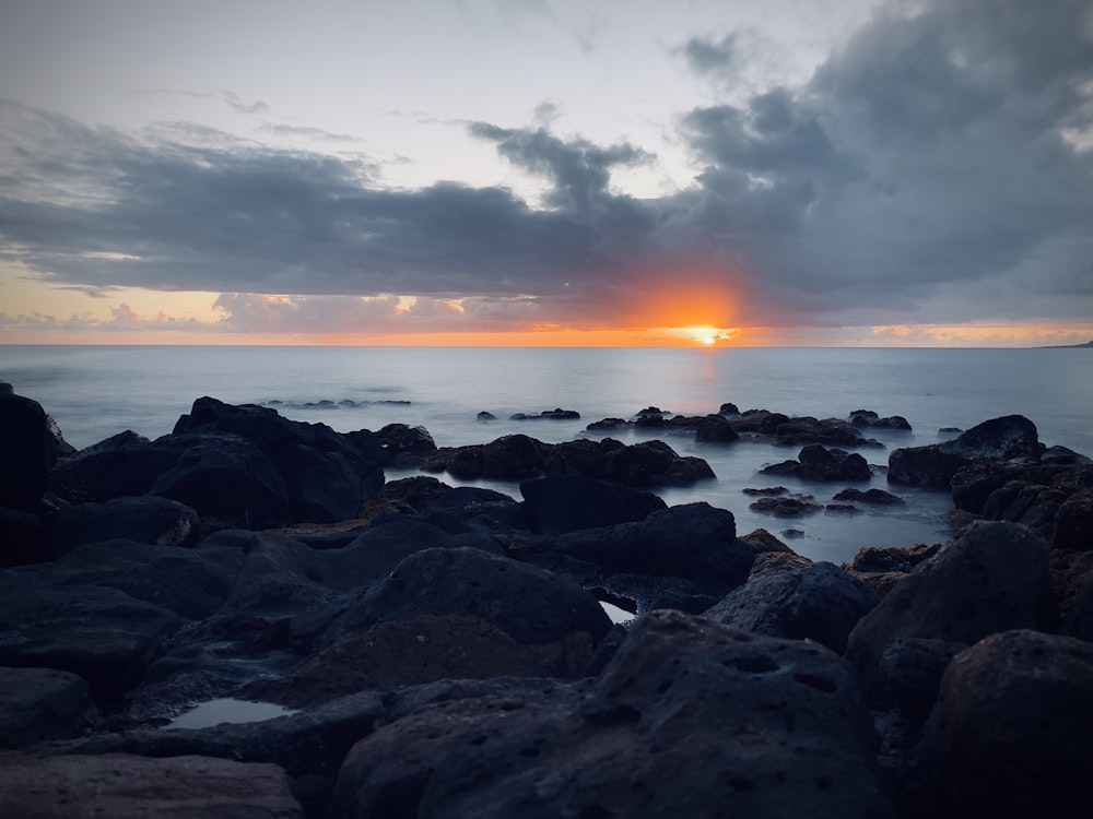 calm body of water under sunset