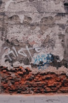 Close-up of a weathered brick wall with bold graffiti art reflecting urban grit.