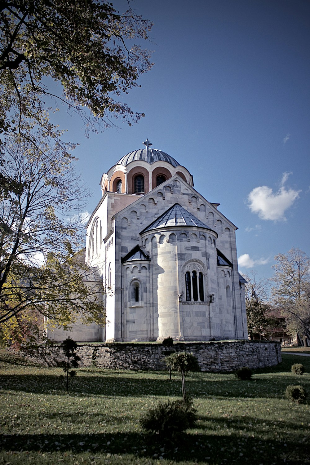 cathedral under blue sky and calm trees