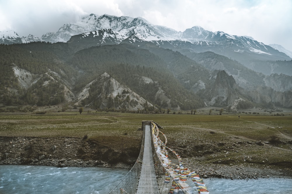 gray bridge near green mountain