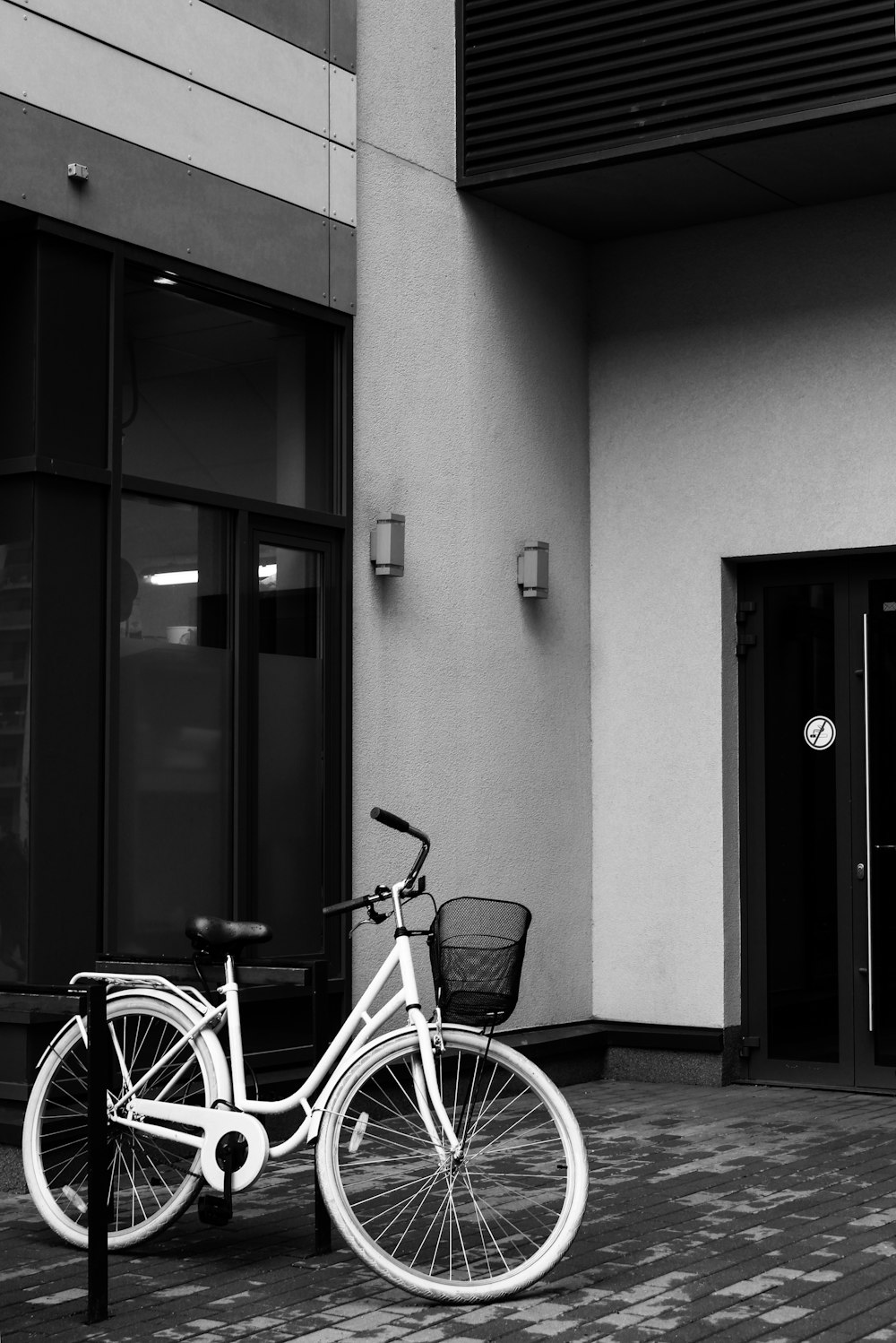 white beach cruiser bicycle parked beside glass window