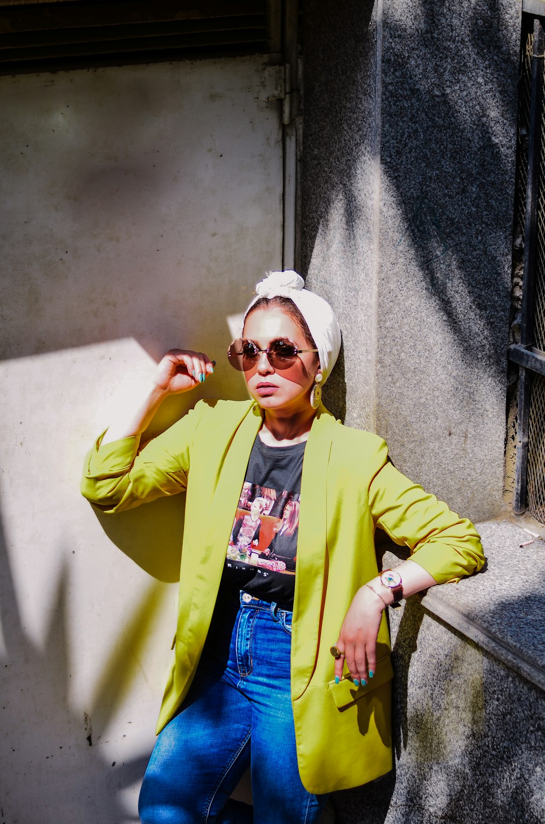 woman in yellow coat beside concrete wall