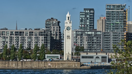 white tower clock beside body of water in Parc Jean-Drapeau Canada