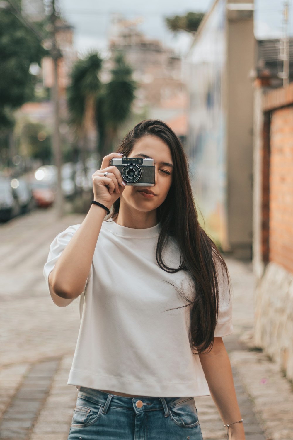 woman holding black and gray bridge camera