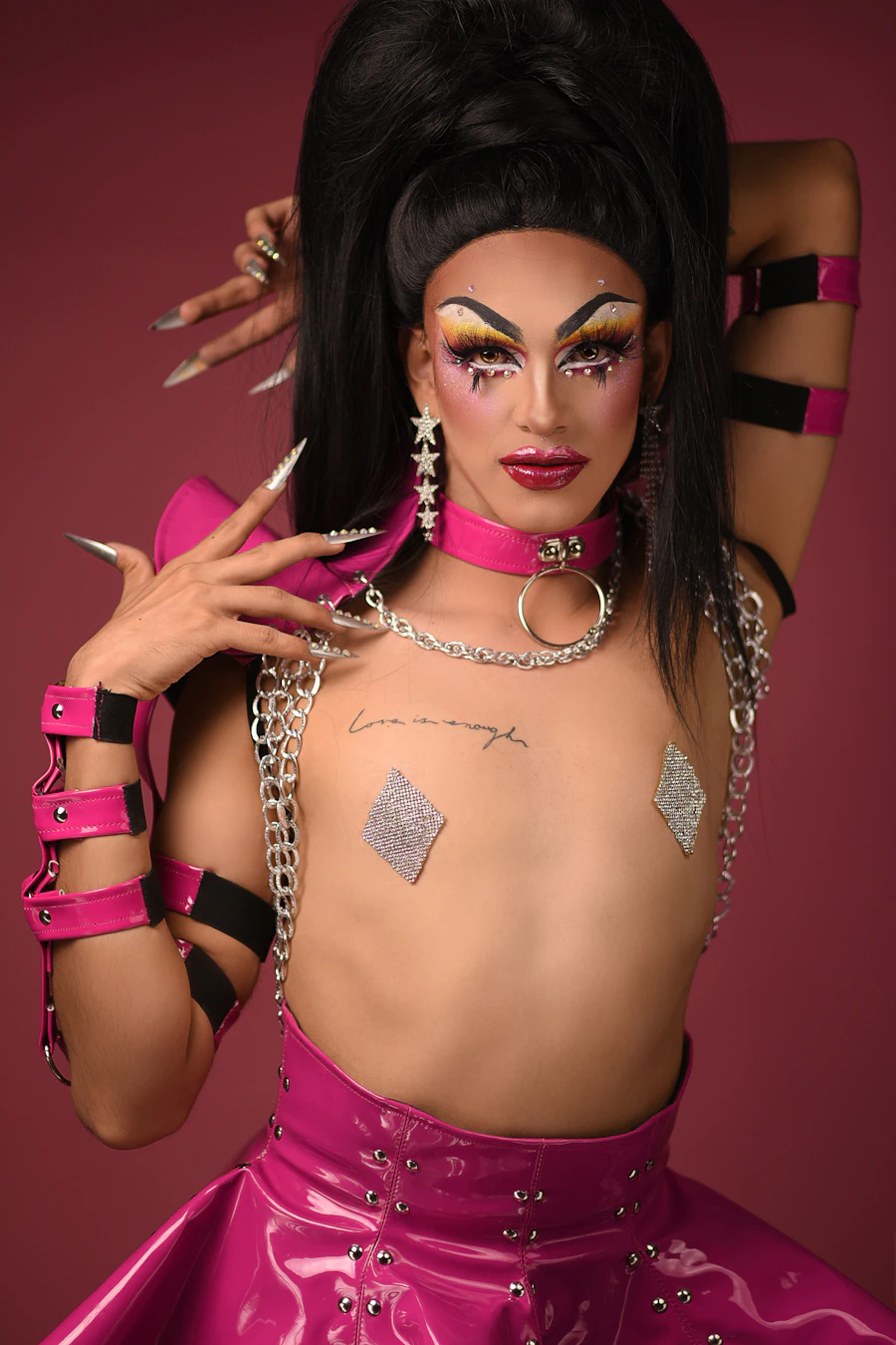 Drag performer DeeJay Alex in a pink patent leather look with dramatic makeup