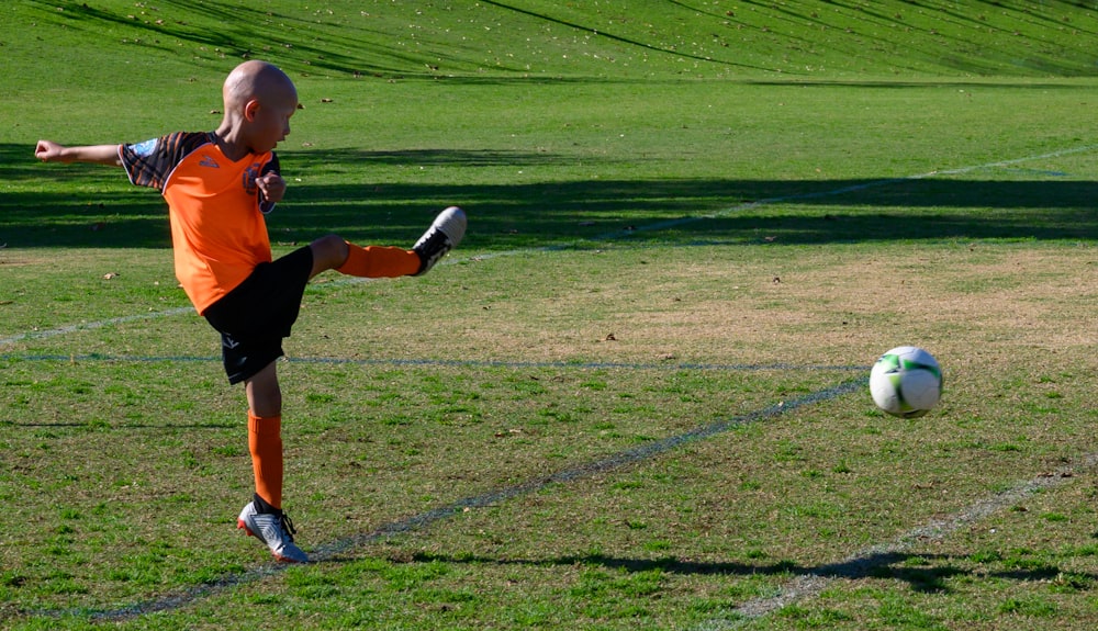 man playing soccer during daytime