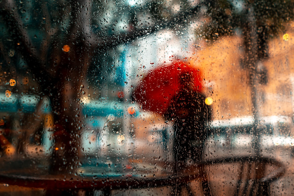 a person holding a red umbrella in the rain