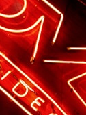 Bright neon lights arranged in geometric shapes and letters combine against a dark background, creating a vibrant and eye-catching display.