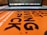 A close-up view of an orange book cover with bold black text, partially focusing on the words 'ART NOT GIVING A FCK'. In the background, a blurred laptop keyboard and screen are visible.