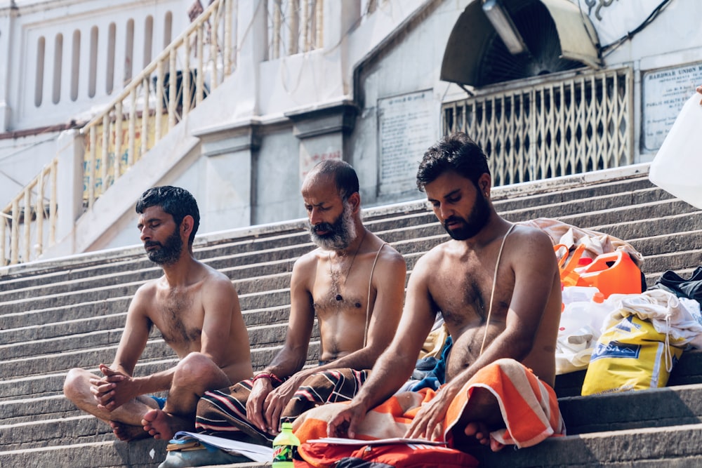 three men sitting on stairs