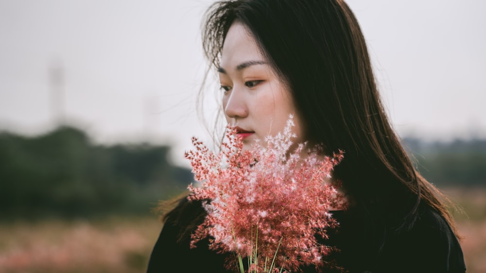 woman holding brown flowers