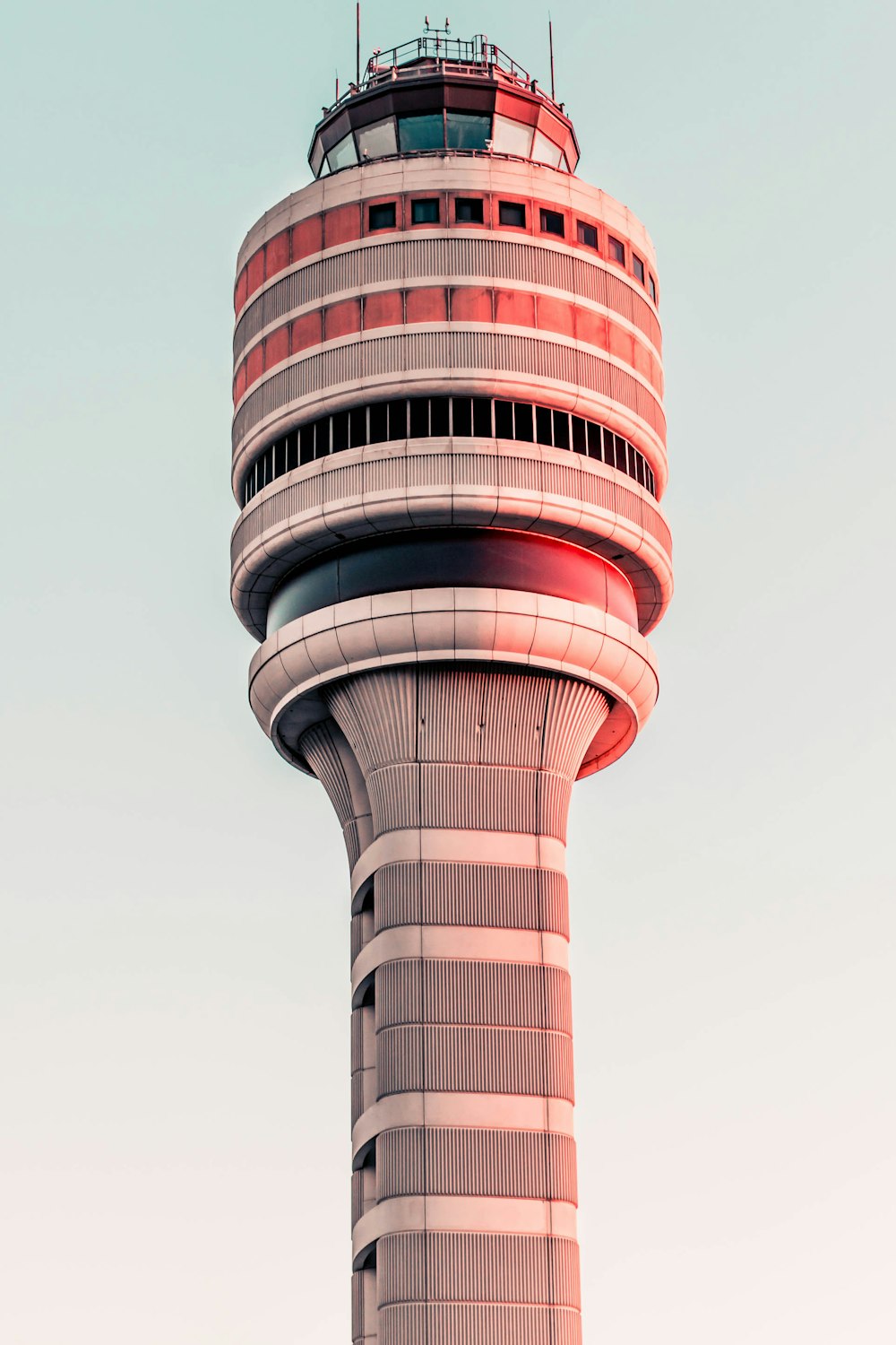 gray and red tower under a calm blue sky