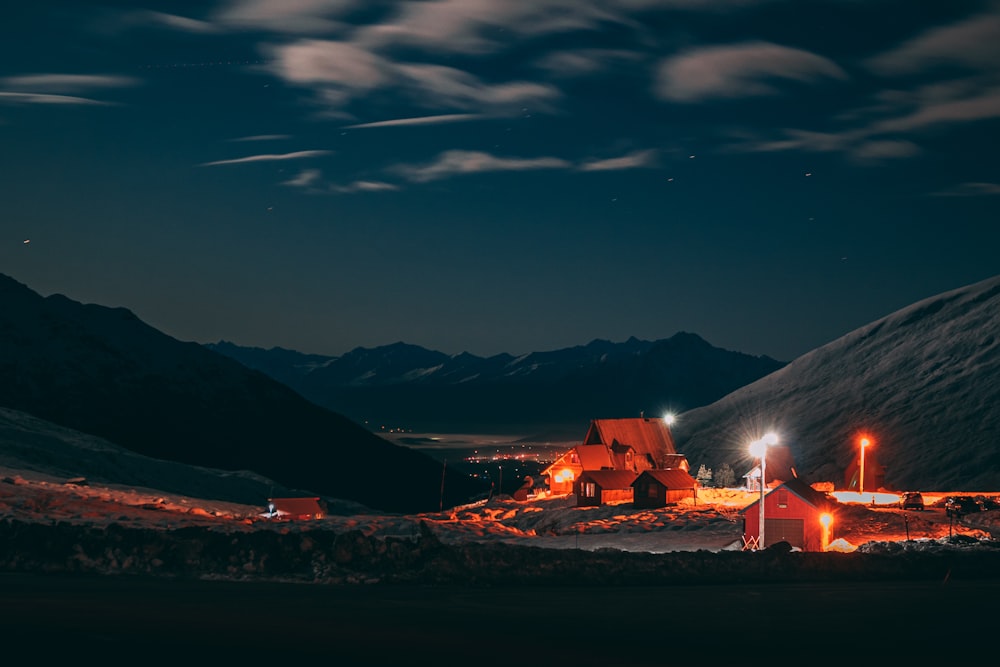 houses near mountain under blue and white sky during night time