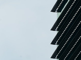Contemporary building facade with a dark gradient overlay and soft shadows.