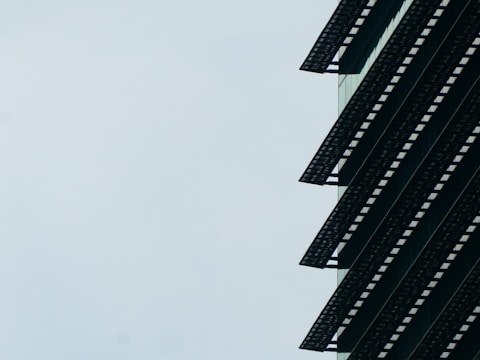 Contemporary building facade with a dark gradient overlay and soft shadows.