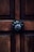 A wooden door with a prominent dark metal decorative knob centrally positioned. The wood features visible grain patterns, adding texture and warmth to the appearance.
