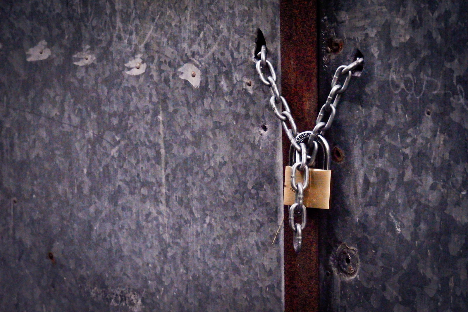 Porte fermée par une chaîne et un cadenas, pour illustrer l'assurance habitation