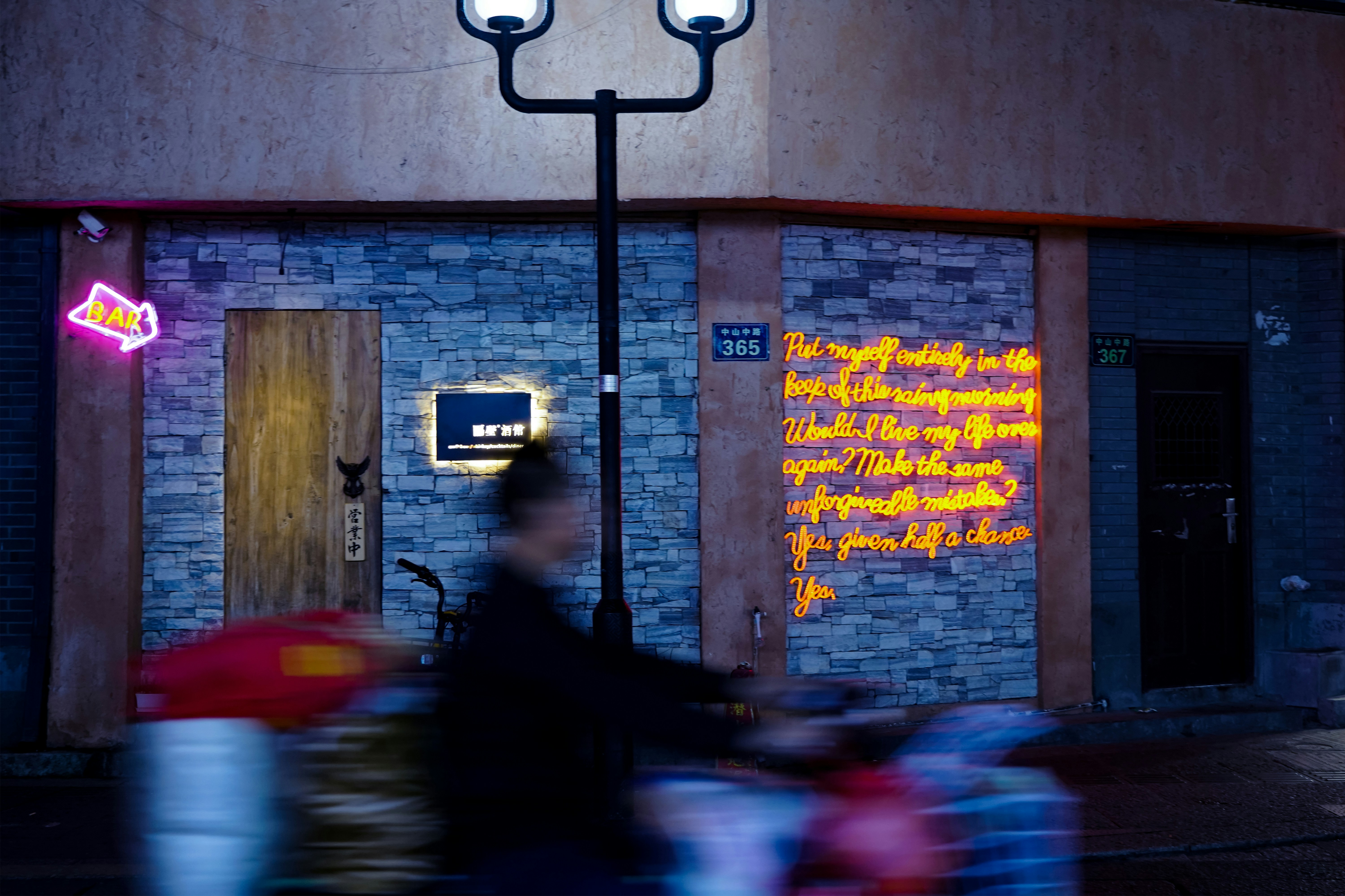 person riding bike beside lamp post