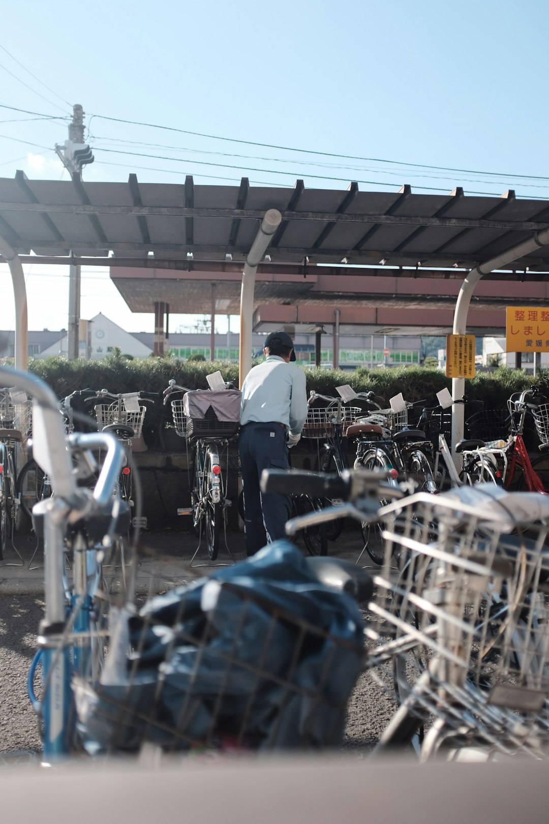 person standing beside bikes under gray shed