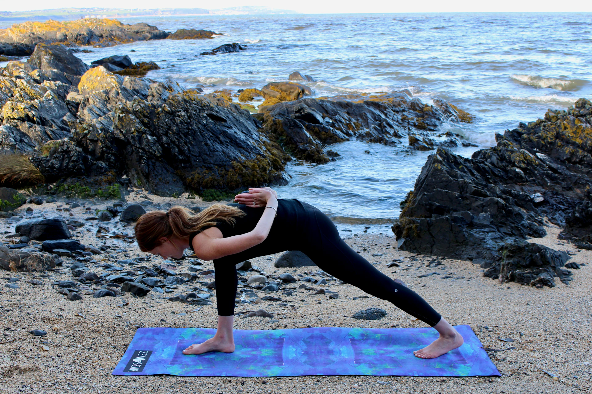 woman doing yoga at beach