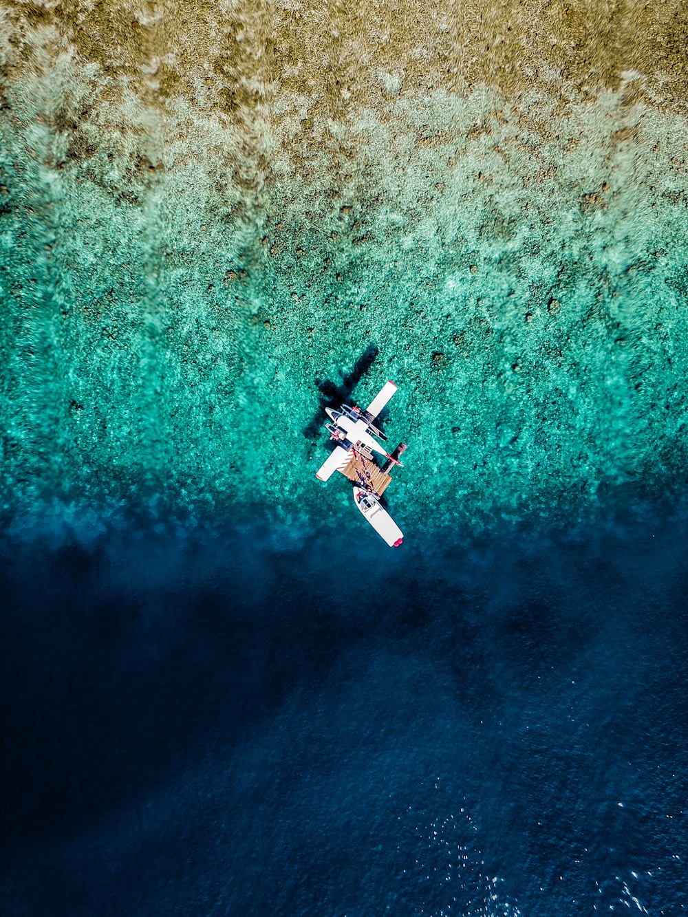 an aerial view of a plane flying over a body of water