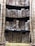 Several rows of aged and weathered books are stacked closely on shelves. Their worn covers and spines suggest a historical or antique feel, with visible dirt and discoloration.
