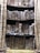 Several rows of aged and weathered books are stacked closely on shelves. Their worn covers and spines suggest a historical or antique feel, with visible dirt and discoloration.